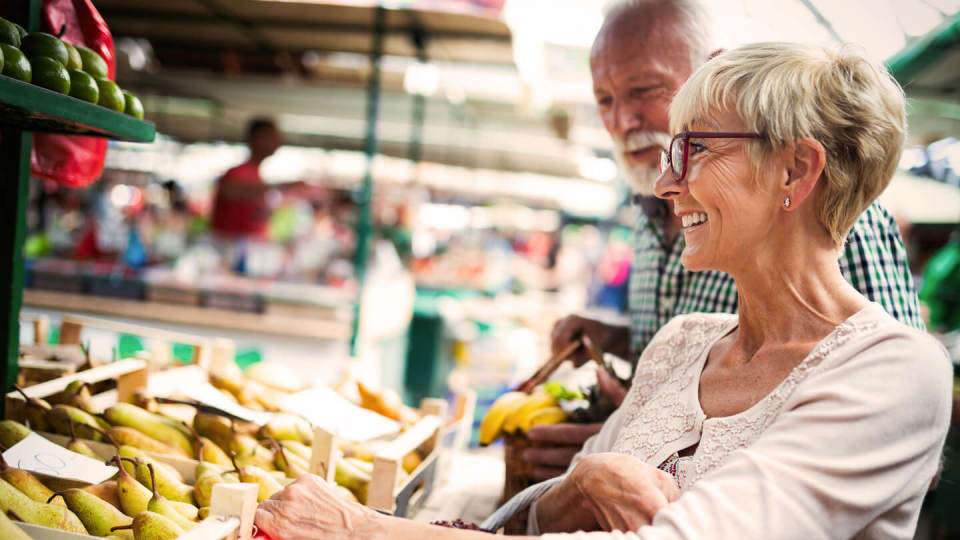 Senior couple buying fresh fruit at the market