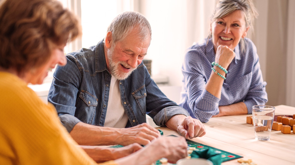 Man playing board game with two women