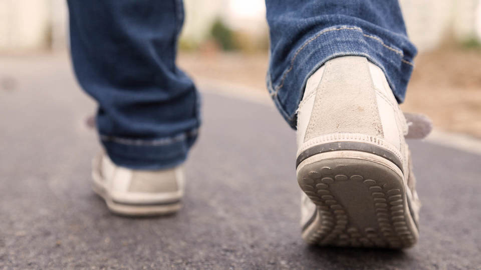 Newsroom - man's feet walking on pavement 