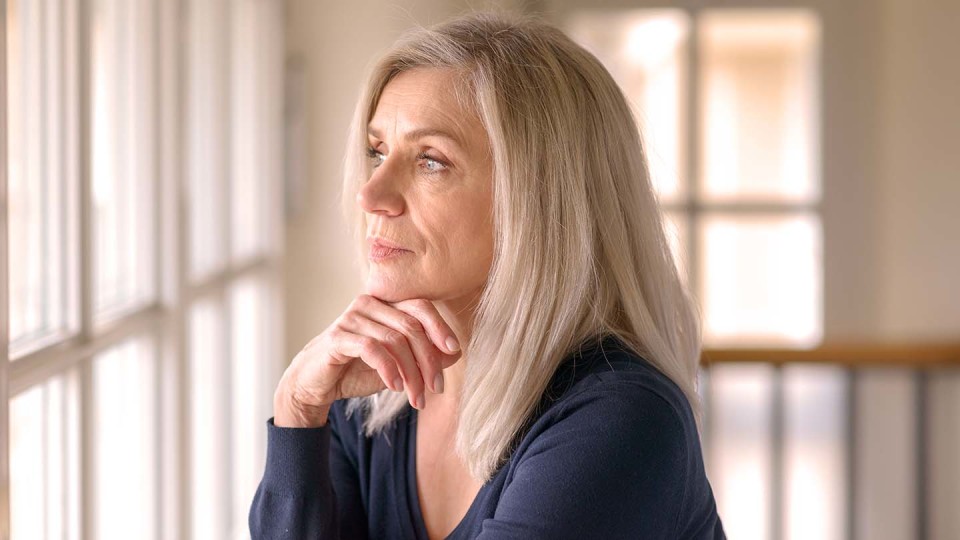 Older looking blond lady looking out of window